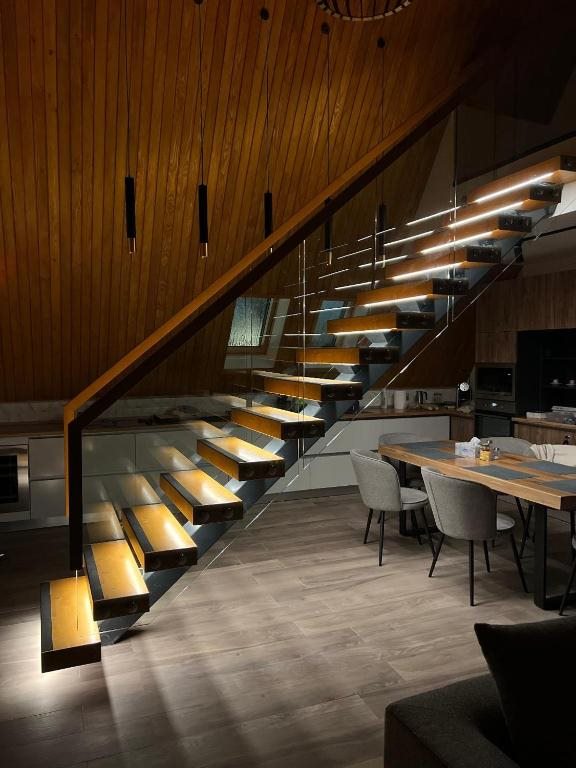 Interiorul AVA Chalet seara, cu lumină caldă pe scară